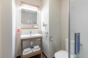 La salle de bains est pourvue d'un lavabo et de toilettes. dans l'établissement Appart’City Confort Reims Centre, à Reims