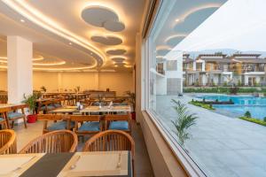 un restaurant avec vue sur la piscine dans l'établissement Evara Spa & Resort, à Rāmnagar