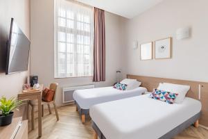 Cette chambre comprend 2 lits et une fenêtre. dans l'établissement Appart’City Confort Reims Centre, à Reims