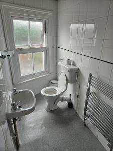 uma casa de banho com um WC e um lavatório em The Swan Hotel em Milton Keynes
