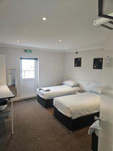 ein Schlafzimmer mit 2 Betten und einem TV in der Unterkunft The Swan Hotel in Milton Keynes