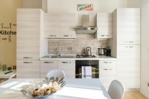 eine Küche mit weißen Schränken und einem Tisch mit einer Schale Muscheln in der Unterkunft Scandellari Apartments - Porta San Felice in Bologna