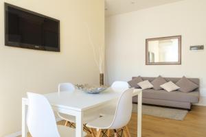une salle à manger blanche avec une table blanche et des chaises blanches dans l'établissement Scandellari Apartments - Charming Bologna apartment, stairs access only, à Bologne