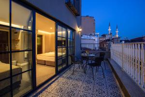 uma varanda com uma cama, uma mesa e cadeiras em Aston Hotel Taksim em Istambul
