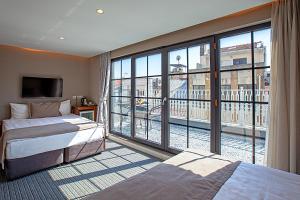 um quarto de hotel com duas camas e uma grande janela em Aston Hotel Taksim em Istambul