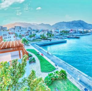- une vue sur le port, les bâtiments et l'eau dans l'établissement Wateera Jebel Sifah, à As Sīfah