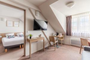 a hotel room with a bed and a window at Appart’City Confort Reims Centre in Reims