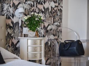 un dormitorio con un tocador con una planta en Hotel Sole en Cannero Riviera