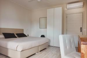 um quarto branco com uma cama e uma cadeira em Hotel Sole em Cannero Riviera