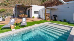 a backyard with a swimming pool and a house at Villa Turística Palomas Torrox by Ruralidays in Torrox