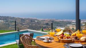 a table with food on it with a view of a pool at Villa Turística Palomas Torrox by Ruralidays in Torrox