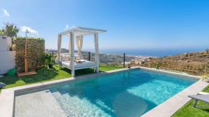 a swimming pool with a gazebo next to a house at Villa Turística Palomas Torrox by Ruralidays in Torrox