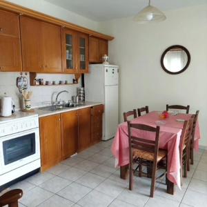 a kitchen with a table with a pink table cloth at Ria's Appartment Egani in Aigáni