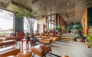 ein Restaurant mit Tischen, Stühlen und Pflanzen in der Unterkunft Pi Boutique Hostel in Da Lat