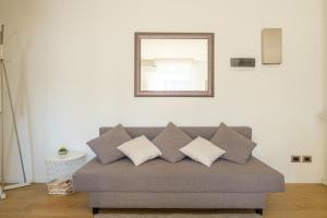ein graues Sofa mit Kissen im Wohnzimmer in der Unterkunft Scandellari Apartments - Porta San Felice in Bologna