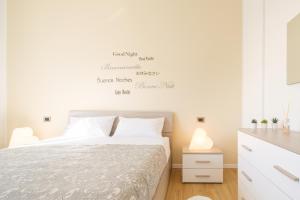 une chambre avec un lit et un mur blanc dans l'établissement Scandellari Apartments - Charming Bologna apartment, stairs access only, à Bologne 30 autres photos