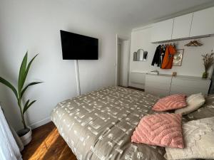 a bedroom with a bed and a flat screen tv at Eiffel Playcation in Paris