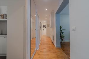 a hallway with white walls and a mirror at Eiffel Playcation in Paris