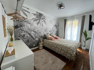 a bedroom with a bed with a tropical wallpaper at Eiffel Playcation in Paris