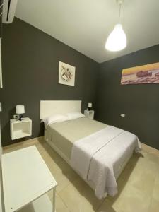 1 dormitorio con cama blanca y paredes verdes en DELUXE ROOM IN APARTMENT SHARED in Los Cristianos Playa HabitaciónSTANZA air-conditioned, en Arona