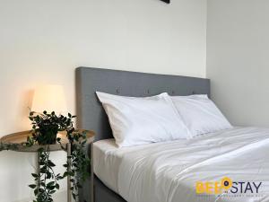 セパンにあるResidensi Lili 10 Mins to Aeon Nilai Shopping Mall Pool View 5PAXのベッド(白い枕付)、テーブル(ランプ付)