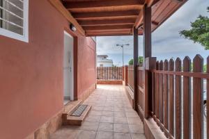 an empty walkway of a house with a fence at Casarossa in Maspalomas