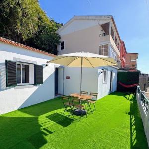 a patio with a table and chairs and an umbrella at Casa D'Avó Filó in Funchal