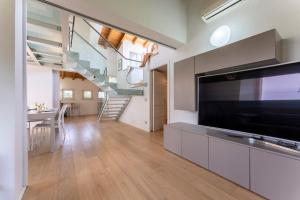 sala de estar con TV grande y escalera en Casa Del Marchese With Private Pool, Castell’arqua en Vigostano