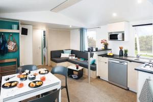 a room with a kitchen and a living room at Camping het Wieskamp in Henxel