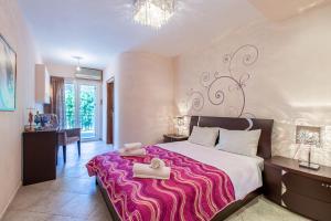 a bedroom with a large bed with a pink blanket at Elena Apartment in Chania