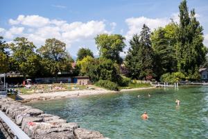 un grupo de personas nadando en un río en HUTTOPIA Divonne en Divonne-les-Bains