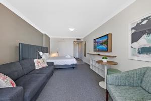 uma sala de estar com um sofá e uma cama em Comfy Studio Next to Chatswood Station em Sydney
