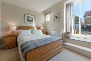 a bedroom with a bed and a window at The Little Barn in Ringstead