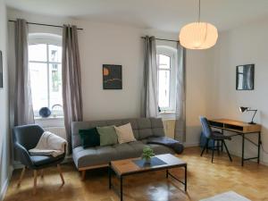 a living room with a couch and a table at ThüringenApartments Südstadt in Saalfeld