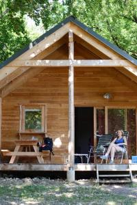 eine Frau, die auf den Stühlen auf der Veranda einer Hütte sitzt in der Unterkunft HUTTOPIA Divonne in Divonne-les-Bains