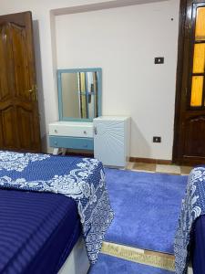 een slaapkamer met een bed, een dressoir en een tv bij Cozy Nile view apartment in Asyut