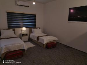 una camera con due letti e una TV a parete di Seleucia DaR Umm Qais a Um Qeis