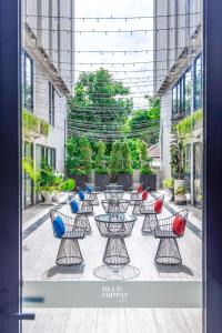 a patio with tables and chairs in a building at Blue Hippo Hotel in Ban Khlong Samrong
