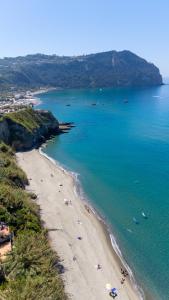 a beach with people and boats in the water at Residence Palummera in Ischia