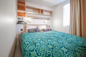 a bedroom with a bed with a blue comforter at Camping het Wieskamp in Henxel