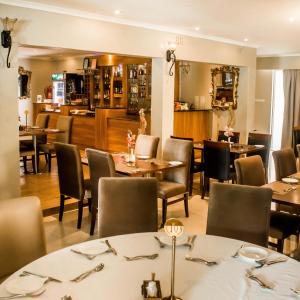 un restaurante con mesas y sillas y un bar en Lotus by Serendib en Blantyre