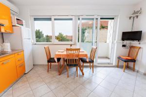 a kitchen with a dining room table and chairs at Apartments Baričević in Bol