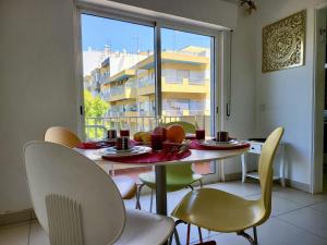 a dining room with a table and chairs and a window at Quarteira Central 2 by Homing in Quarteira