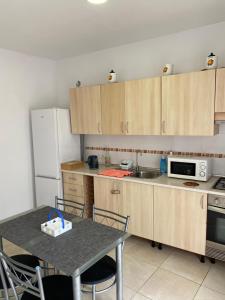a kitchen with wooden cabinets and a table and a refrigerator at DELUXE ROOM IN APARTMENT SHARED in Los Cristianos Playa HabitaciónSTANZA air-conditioned in Arona