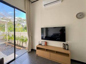 a living room with a large flat screen tv on the wall at Cosmo Villa by Labala in Ban Klang Na