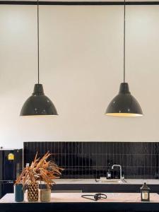 a kitchen with three pendant lights above a sink at Cosmo Villa by Labala in Ban Klang Na +41 photos