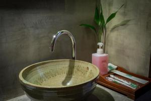 a sink with a bowl of water in it at Le Tigre Hotel in Siem Reap