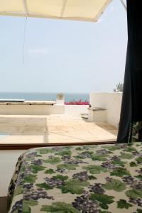 a bed in a room with a view of the ocean at Capitolo in Monopoli +30 photos