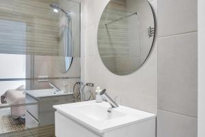 a white bathroom with a sink and a mirror at Apartamento Guzmán B in Barbate +12 photos
