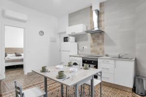 a white kitchen with a table and a stove at Apartamento Guzmán B in Barbate